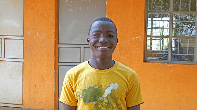 Von der Goldmine zur Bildung: David (17) vor seiner Schule.