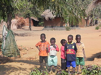 Fünf malawische Kinder auf einem Dorfplatz