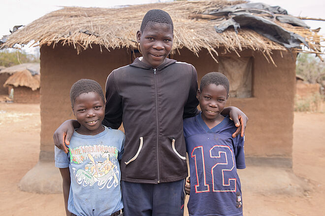 3 Jungs vor einer Hütte. Bild: TearFund Schweiz