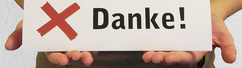 Sie befinden sich im Bereich Aktiv werden: Spenden Hände halten ein Danke-Schild