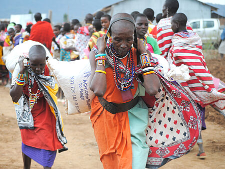 In ihren traditionellen Trachten trugen selbst Kinder und alte Frauen - dennoch dankbar - am Horn von Afrika schwere Lebensmittelsäcke. Bild: Jaqueline Koster / CRWRC