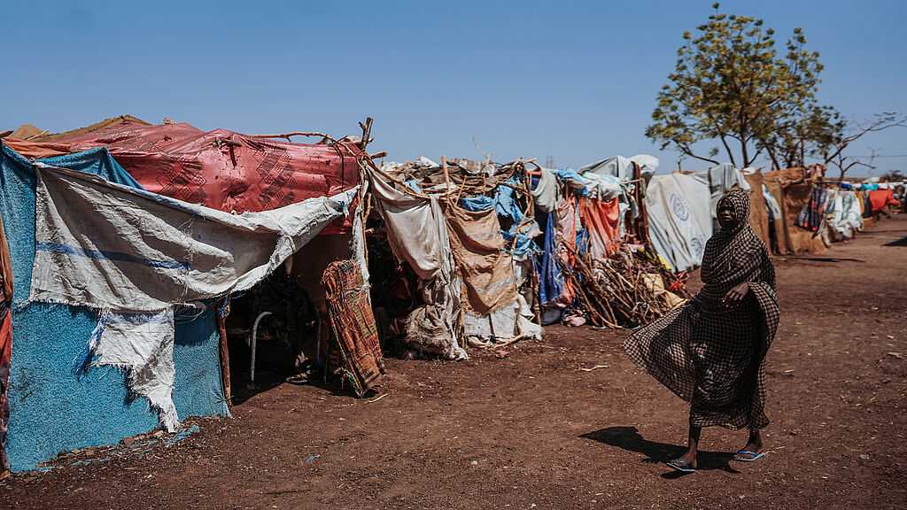 Frau unterwegs in Vertriebenencamp im Sudan.