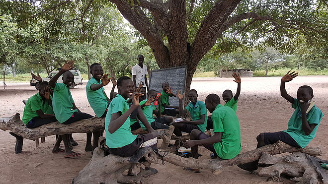 Kinder einer Schulstufe lernen in ihrem einfachen «Klassenzimmer» unter einem Baum. Bild: Anna Abel / TearFund Schweiz  