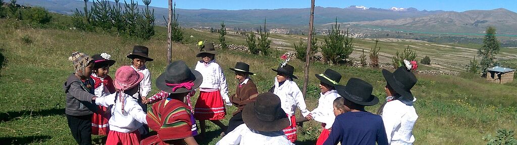 Peruanische Kinder tanzen im Kreis