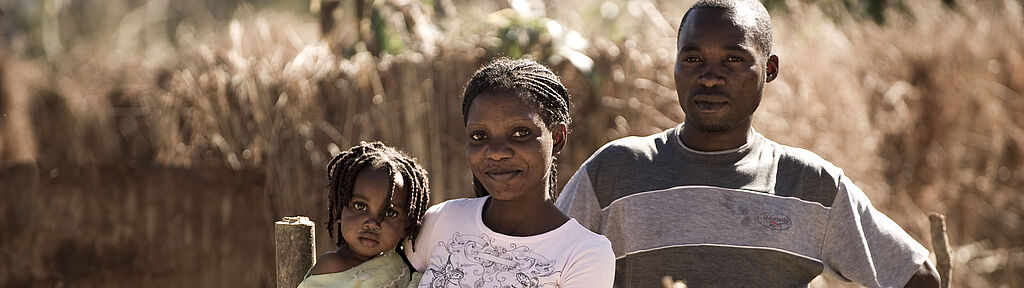 Sie befinden sich im Bereich "Wie wir arbeiten". Auf dieser Seite berichten wir Ihnen über Vision & Leitbild unserer Arbeit Eine junge afrikanische Familie lächelt in die Kamera.
