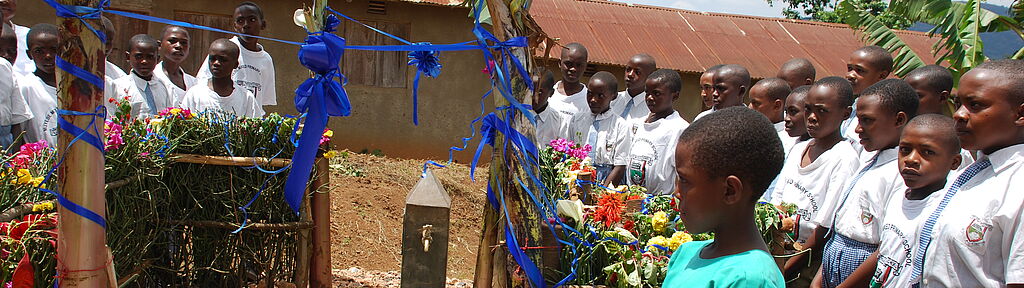 Institutionen: Ugandische Schulmädchen bei der Einweihung eines Brunnens.