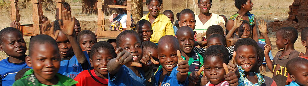 Sie befinden sich im Bereich Länder und Projekte: Malawi Kindergruppe in Malawi strahlt in die Kamera.