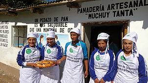 Jugendliche aus Peru zeigen während einer Schnupperlehre selbstgebackene Brote.
