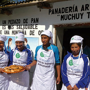Jugendliche in Peru präsentieren während einer Schnupperlehre selbstgebackene Brote.