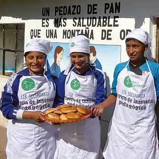 Jugendliche in Peru zeigen während einer Schnupperlehre ihre selbstgebackenen Brote. 