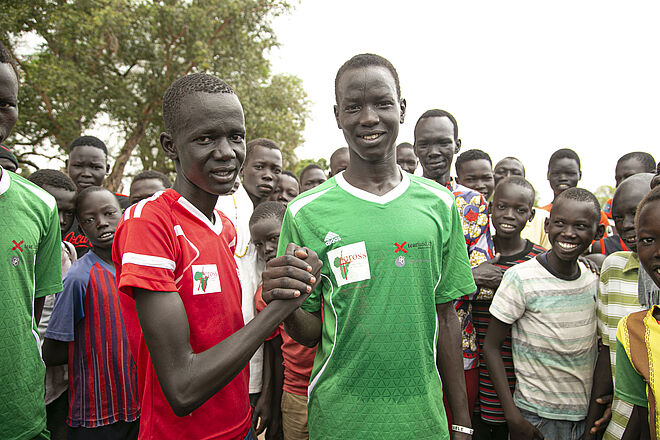 Marial und der gegnerische Mannschafts-Kapitän grüssen sich für das gemeinsame Fussballspiel. Bild: Anna Abel, für TearFund Marial und der gegnerische Mannschafts-Kapitän grüssen sich für das gemeinsame Fussballspiel. Bild: Anna Abel, für TearFund