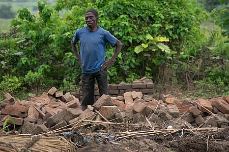 Moleni aus Chikwawa steht in den Trümmern seines Hauses und seines Lebensmittelgeschäftes. Bild: Evangelical Alliance Malawi